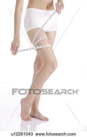 Young woman wearing shorts and measuring leg with tape measure View Large Photo Image Stock Image - Young woman wearing shorts and measuring leg with tape measure. Fotosearch