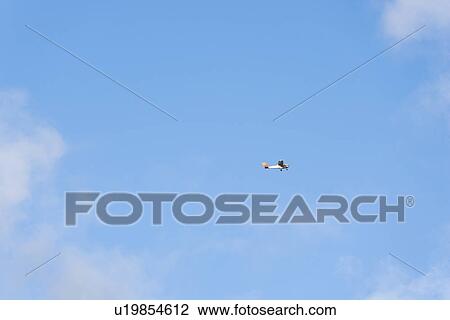 Stock Image - Airplane Flying in the Blue Sky, Hawaii, USA. Fotosearch