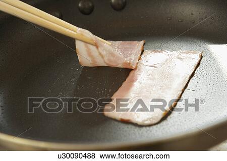 Bacon being fried in pan, close up View Large Photo Image Stock Photo - Bacon being fried in pan, close up. Fotosearch