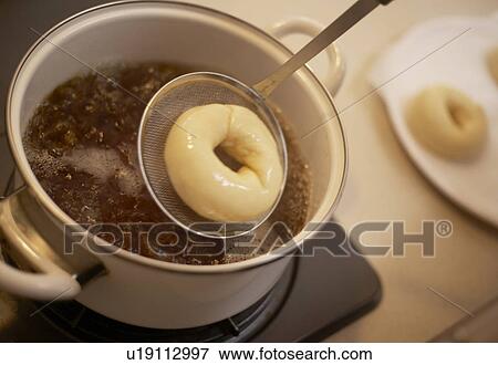 Bagel dough being boiled in pan, close up View Large Photo Image Stock Photo - Bagel dough being boiled in pan, close up. Fotosearch