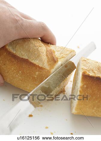 Stock Photograph - Baguette being sliced. Fotosearch