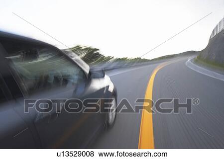Stock Photo - Blurred view of car driving on road. Fotosearch