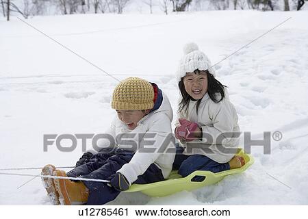 Boy and girl on a sled View Large Photo Image Stock Image - Boy and girl on a sled. Fotosearch