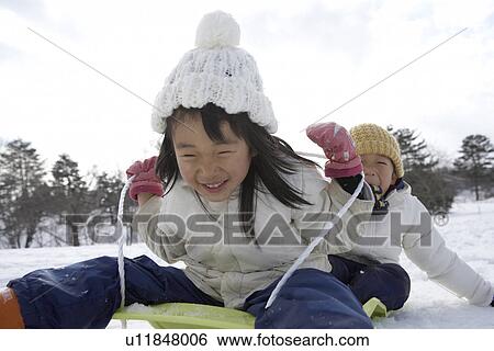 Stock Photograph - Boy and girl on a sled. Fotosearch