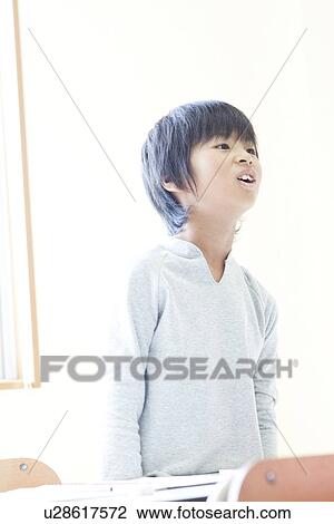 Stock Image - Boy answering to a question at cram school. Fotosearch