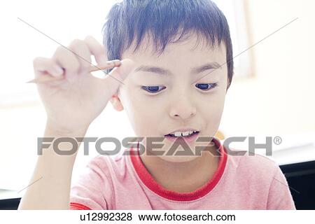Stock Photo - Boy at cram school thinking. Fotosearch