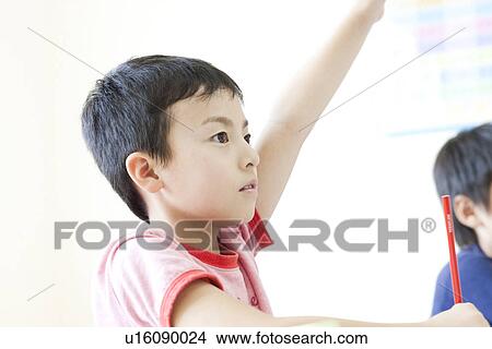Picture - Boy raising her hand at cram school. Fotosearch