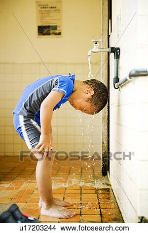 Picture - Boy washing himself with water. Fotosearch