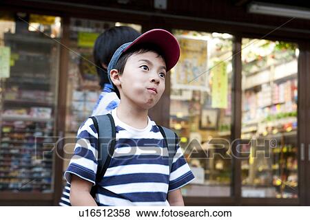 Stock Photo - Boy with candy in his mouth in front of Dagashi-ya. Fotosearch