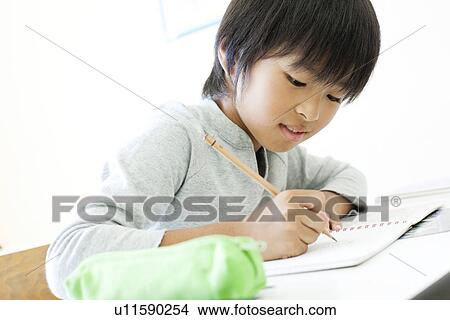 Boy writing on notebook at cram school View Large Photo Image Picture - Boy writing on notebook at cram school. Fotosearch
