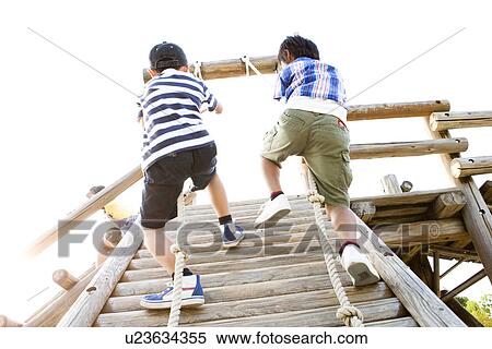 Stock Photography - Boys climbing up using a rope. Fotosearch