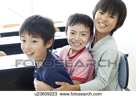 Stock Image - Boys sitting on each others lap. Fotosearch