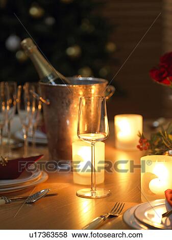 Stock Photo - Burning candles and champagne bottle, long exposure. Fotosearch