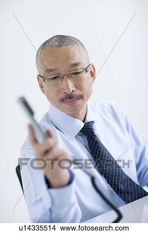 Businessman holding phone receiver, white background View Large Photo Image Picture - Businessman holding phone receiver, white background. Fotosearch