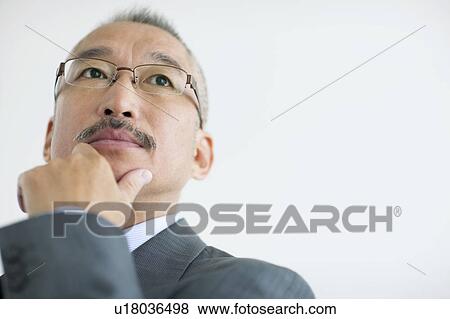 Businessman looking away, close up, white background View Large Photo Image Stock Photo - Businessman looking away, close up, white background. Fotosearch