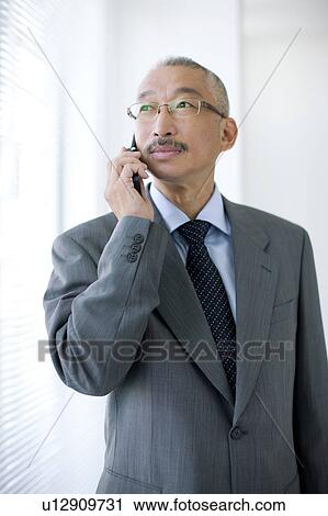 Stock Image - Businessman using mobile phone. Fotosearch