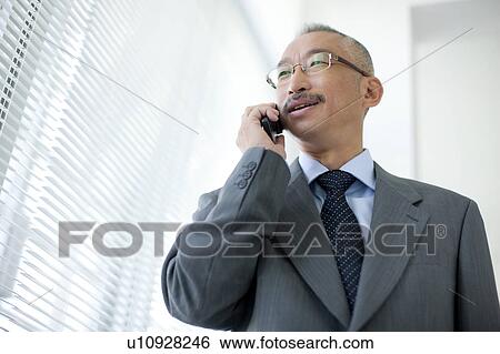 Businessman using mobile phone View Large Photo Image Stock Photograph - Businessman using mobile phone. Fotosearch