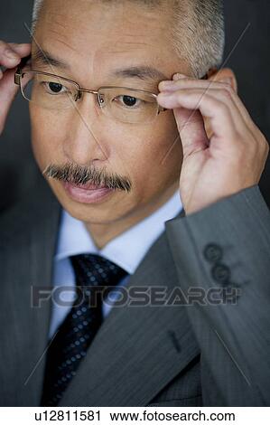 Stock Image - Businessman wearing glasses, close up. Fotosearch