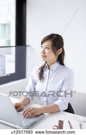 Businesswoman looking away whilst typing View Large Photo Image Stock Image - Businesswoman looking away whilst typing. Fotosearch