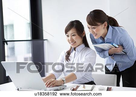 Stock Image - Businesswomen looking at laptop . Fotosearch