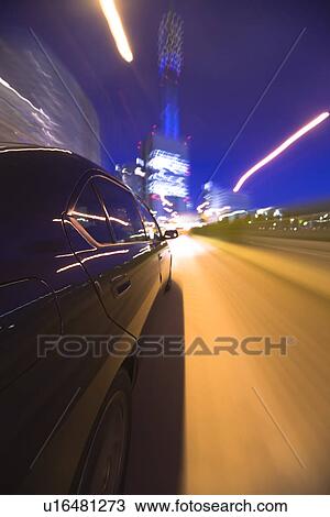 Stock Image - Car driving on road at night. Fotosearch