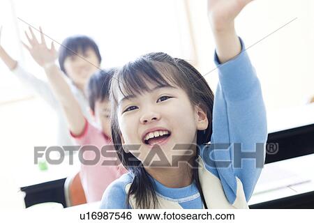 Stock Photograph - Children with their hand raised at cram school. Fotosearch