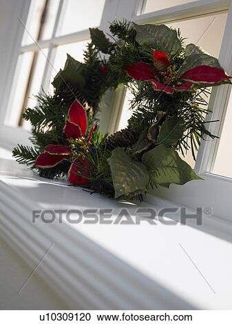 Stock Image - Christmas wreath on window sill, close up. Fotosearch