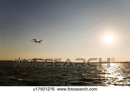 Stock Photograph - Commercial plane flying at dusk. Fotosearch