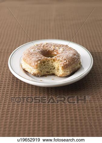 Doughnut with bite mark on plate View Large Photo Image Stock Photo - Doughnut with bite mark on plate. Fotosearch