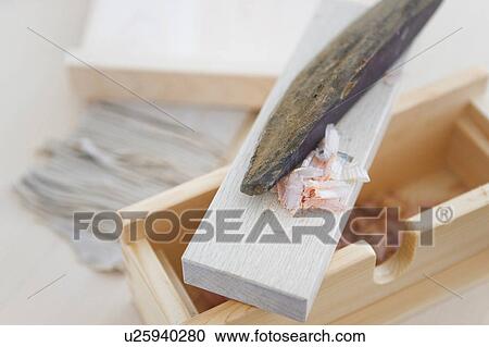 Stock Image - Dried bonito on grater, close up. Fotosearch
