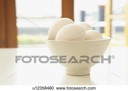 Stock Image - Eggs in bowl, close up. Fotosearch