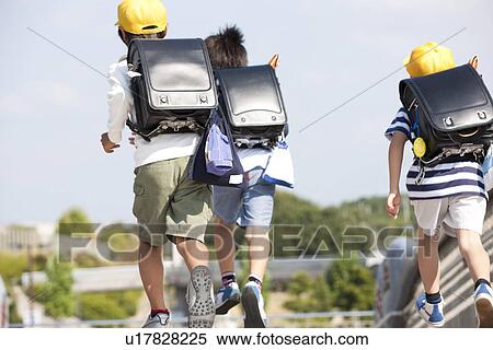 Elementary school students running to school, rear view View Large Photo Image Stock Photography - Elementary school students running to school, rear view. Fotosearch