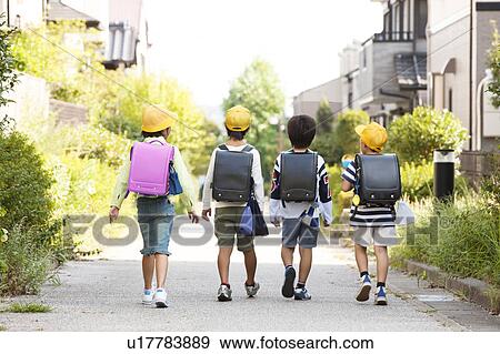 Elementary school students walking to school, rear view View Large Photo Image Stock Photo - Elementary school students walking to school, rear view. Fotosearch