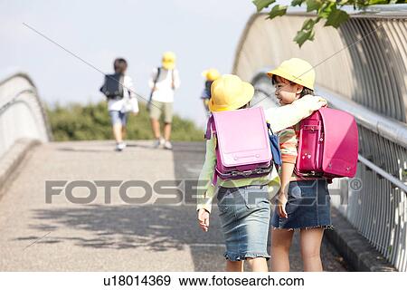 Elementary school students walking to school, rear view View Large Photo Image Stock Photo - Elementary school students walking to school, rear view. Fotosearch