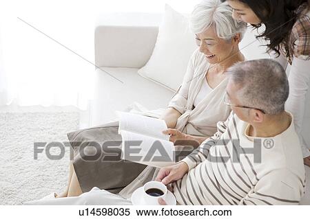 Stock Photography - Family in living room, parents sitting on sofa. Fotosearch