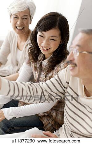 Family sitting on sofa, smiling View Large Photo Image Stock Image - Family sitting on sofa, smiling. Fotosearch