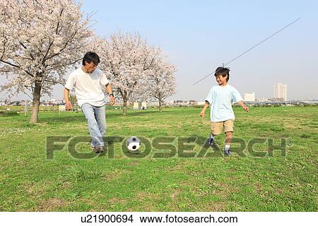 Picture - Father and son playing soccer. Fotosearch