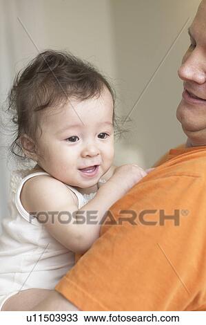Stock Image - Father holding baby. Fotosearch