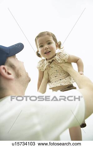 Stock Image - Father lifting daughter in the air. Fotosearch