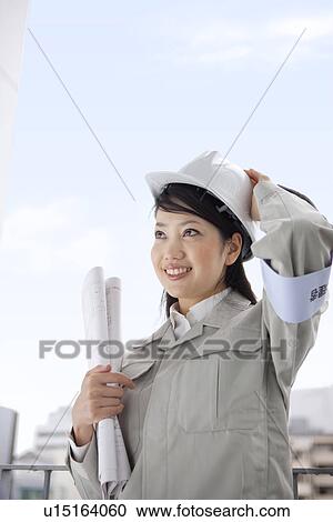 Female architect with a blueprint wearing a hardhat View Large Photo Image Stock Image - Female architect with a blueprint wearing a hardhat. Fotosearch