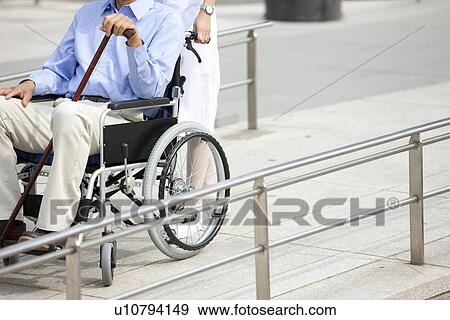 Female nurse pushing man in wheelchair View Large Photo Image Stock Photo - Female nurse pushing man in wheelchair. Fotosearch
