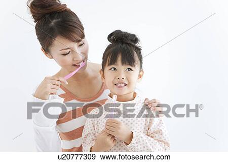 Girl and woman brushing teeth, white background View Large Photo Image Stock Photo - Girl and woman brushing teeth, white background. Fotosearch