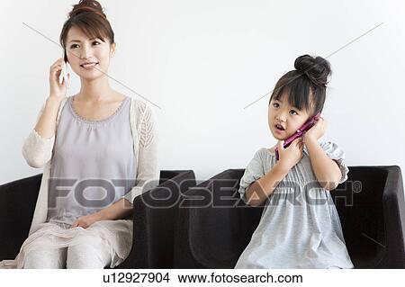 Girl and woman using mobile phone, white background View Large Photo Image Picture - Girl and woman using mobile phone, white background. Fotosearch
