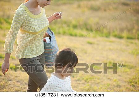 Stock Image - Girl and woman walking in field. Fotosearch