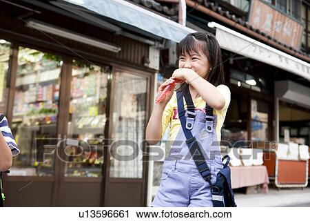 Girl drinking juice in front of Dagashi-ya View Large Photo Image Stock Image - Girl drinking juice in front of Dagashi-ya. Fotosearch