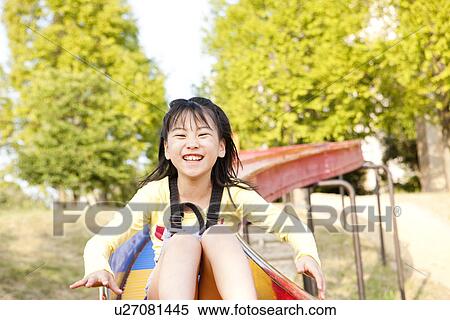 Stock Photography - Girl going down a slide. Fotosearch