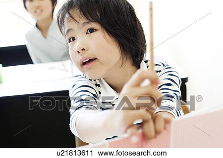 Stock Image - Girl holding a pencil and notebook. Fotosearch