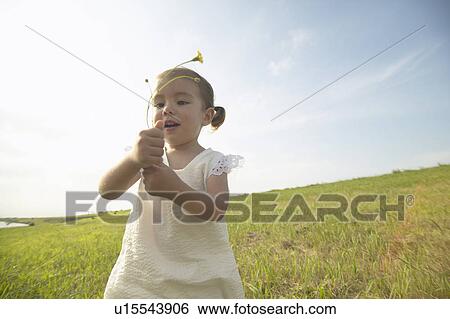 Stock Photograph - Girl holding wildflowers. Fotosearch