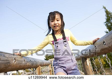 Picture - Girl on playground equipment. Fotosearch