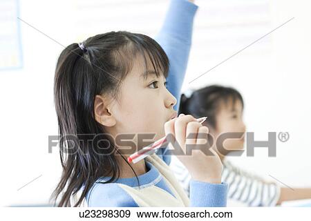 Stock Photo - Girl raising her hand at cram school. Fotosearch